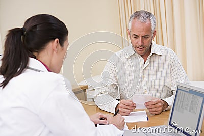 Doctor with laptop and man in doctor s office