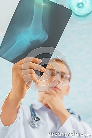 Doctor looks at x-ray image of knee joint