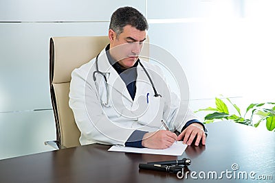 Doctor man sitting in hospital office desk portrait