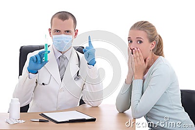 Doctor in mask with syringe and terrified female patient isolate
