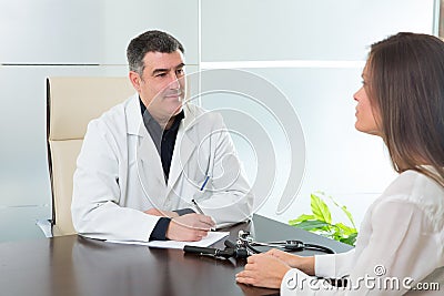 Doctor man and patient woman on hospital office talking