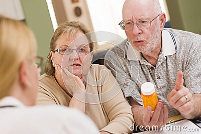 Doctor or Nurse Explaining Prescription Medicine to Senior Coupl