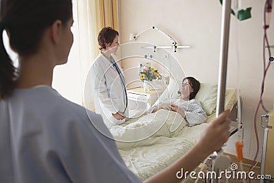 Doctor And Nurse With Patient In Hospital Room