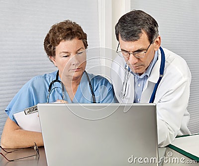 Doctor and Nurse Reviewing on Laptop Computer in O