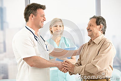 Doctor shaking hands with senior patient