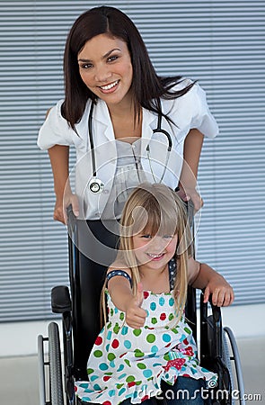 Doctor and Smiling girl on a wheelchair
