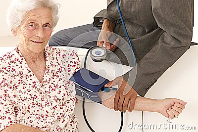 Doctor taking blood pressure to patient at home