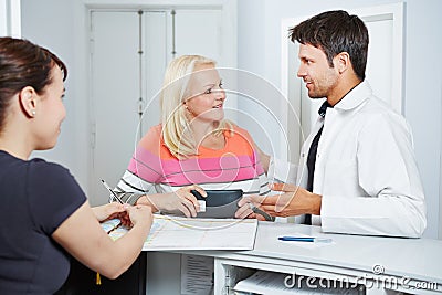 Doctor talking with senior woman at reception