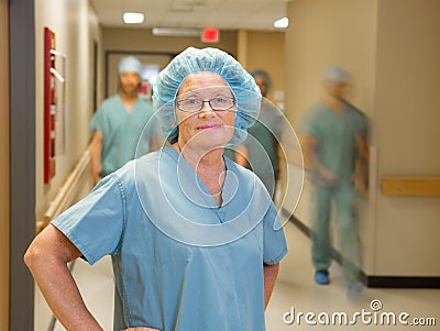Doctor With Team Walking In Hospital Corridor
