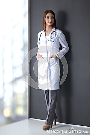 Doctor woman with stethoscope isolated on grey