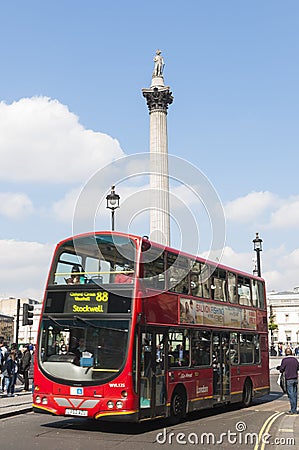 Double-decker bus driving by Trafalgar Square