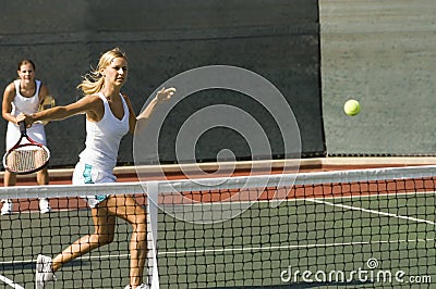 Doubles Player Hitting Tennis Ball With Backhand