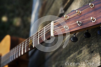 Downward View of Guitar Fret Board Against a Fence