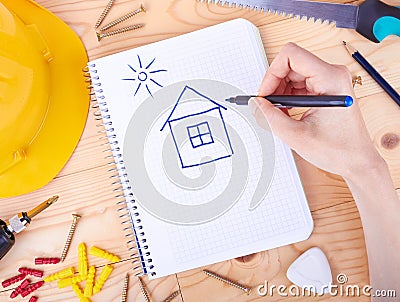 Drawing house and different tools on a wooden background