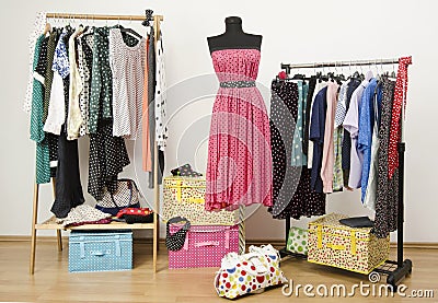 Dressing closet with polka dots clothes arranged on hangers and a dress on a mannequin.