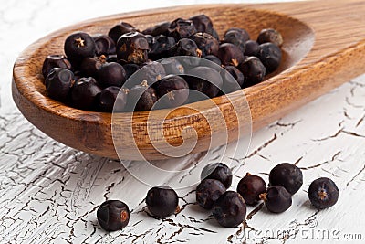 Dried juniper berries on spoon