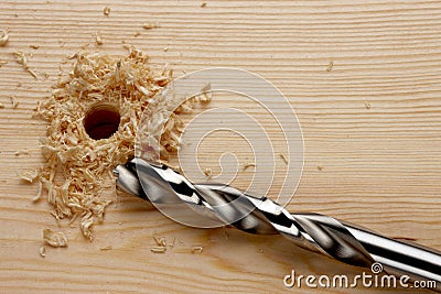 Drill bit next to hole in wood