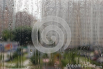 Drops of rain on glass against city background