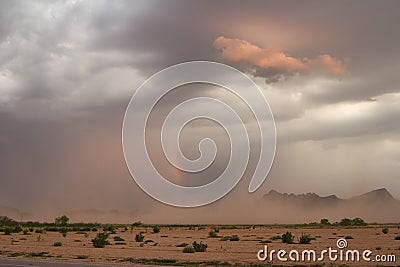 Desert dust storm, or haboob, with rainbow at sunset.