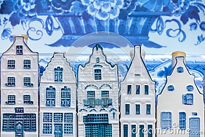 Dutch Delft blue souvenir houses in front of an old plate