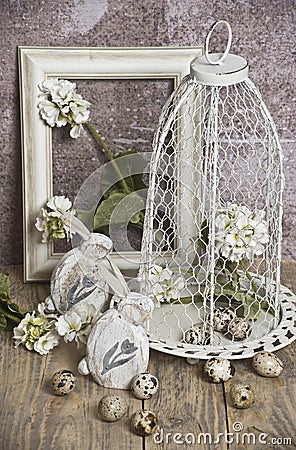 Easter eggs in a cage, spring white flowers, quail eggs, white bunnies