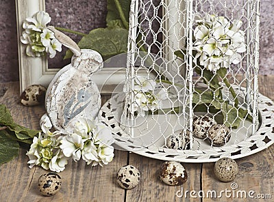 Easter eggs in a cage, spring white flowers, quail eggs, white bunnies