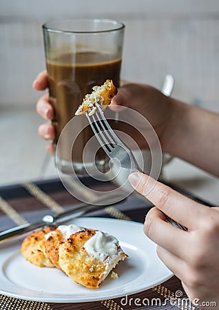 Eat curd cheese pancakes with sour cream for breakfast, hands