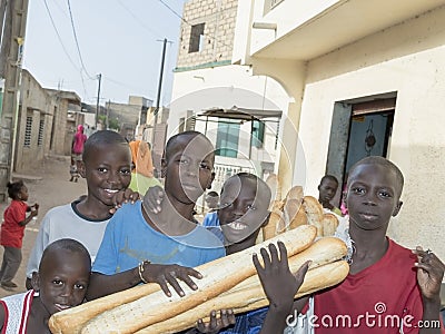 Editorial caption: Thiaroye, Senegal, Africa – July 28, 2014: Unidentified children (bread delivery boys) in the street