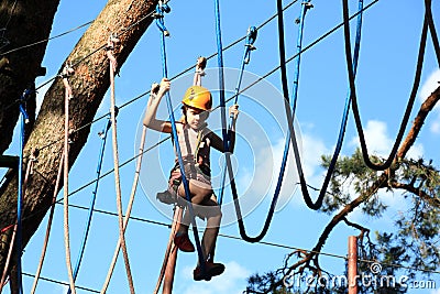 Eenager climbing a rope park, Girl climbing in adventure park