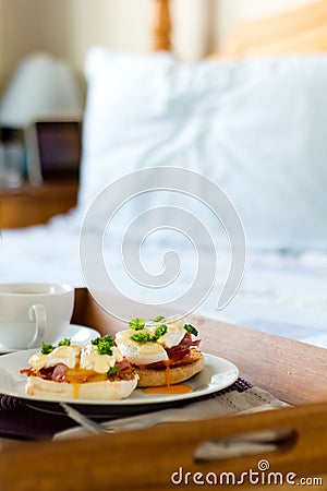 Eggs Benedict on breakfast tray on bed