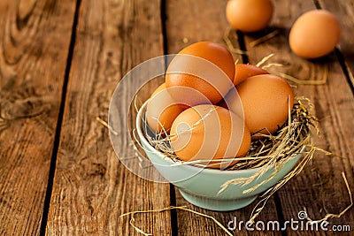 Eggs in a blue bowl on rustic vintage wood