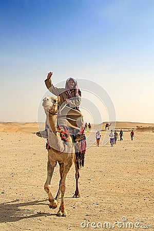 Egyptian guide offering to tourists camel ride