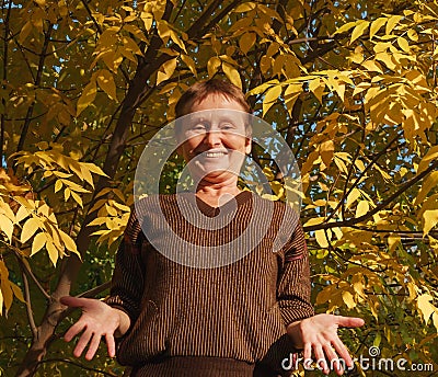 Elder woman shrug shoulder on the background of colorful leaf