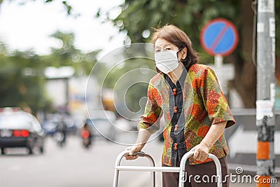 Elderly chinese woman wearing mask for protect air pollution .