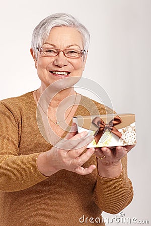 Elderly lady holding small present box smiling