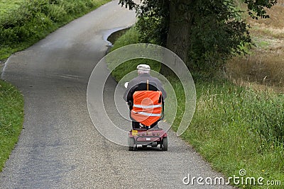 Elderly man riding mobile scooter, Netherlands