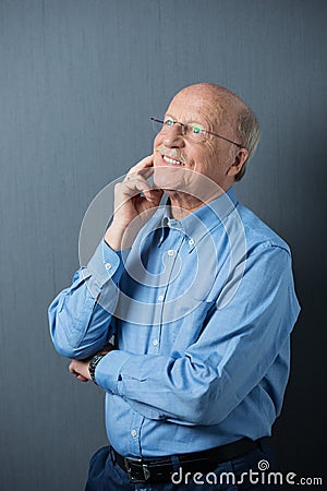 Elderly man standing thinking with a happy smile