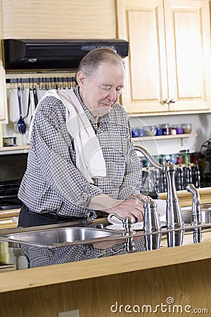 Elderly man washing dishes