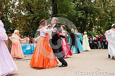 Elderly steams in ball suits dance on city square