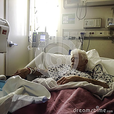 Elderly, white haired male patient in hospital bed