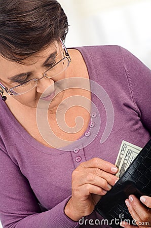 Elderly woman holding wallet with money