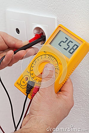 Electrician hands measuring voltage in electrical outlet