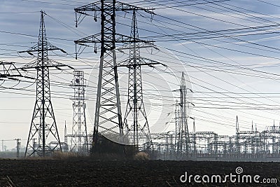 Electricity pylons with distribution power station blue cloudy sky background