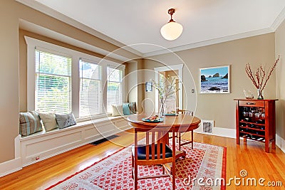 Elegant dining room with window bench with cherry hardwood floor.