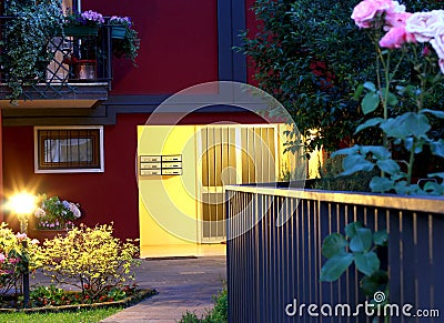 Elegant entry of a luxury home at night with lamp and roses