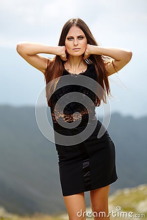 Elegant lady in dress standing on the mountain rocks