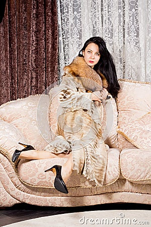 http://thumbs.dreamstime.com/x/elegant-wealthy-woman-long-brunette-hair-sitting-comfortably-upholstered-sofa-clutching-her-luxurious-fur-coat-around-her-29762725.jpg