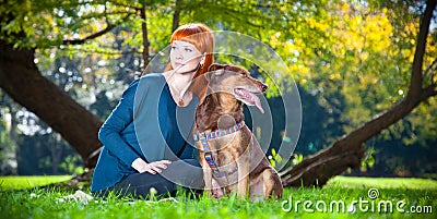 Elegant woman has fun with her big dog in the park