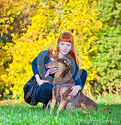 Elegant woman has fun with her big dog in the park