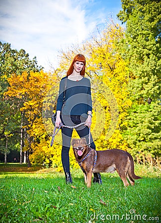 Elegant woman has fun with her big dog in the park